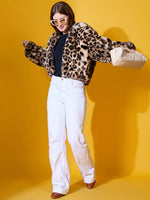 Woman in 98degreenorth Women's Camel Faux Fur Hooded Jacket poses against a bright yellow background.