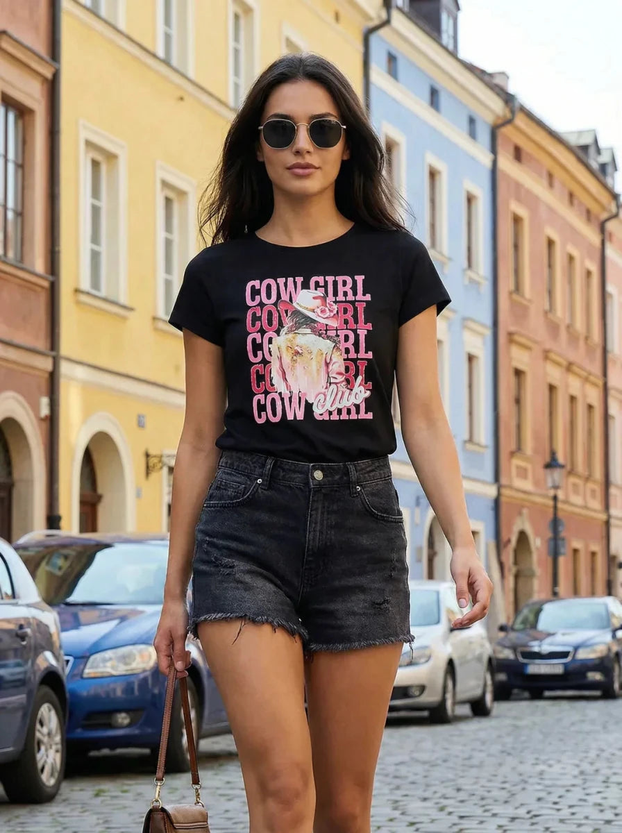 Woman in sunglasses wears a 98degreenorth 100% cotton Women’s casual typography t-shirt and black shorts on a city street.