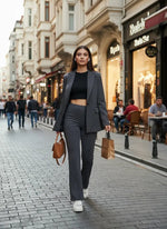 A woman in 98degreenorth charcoal flared bootcut cotton stretchable trousers walks on a city street.