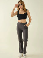 Woman in sunglasses, a black crop top, and 98degreenorth's charcoal flared cotton trousers poses against a plain background.