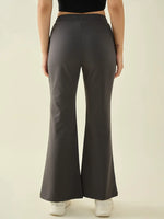 A person in 98degreenorth Women’s Charcoal Flared Fit Bootcut Cotton Trousers and white sneakers, seen from the back.