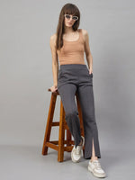 Woman in sunglasses and peach tank wears 98degreenorth Charcoal Grey Bootcut Sweatpants, leaning on a stool.