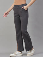 She wears 98degreenorth Women’s Charcoal Grey Bootcut Sweatpants, a beige top, and white sneakers.