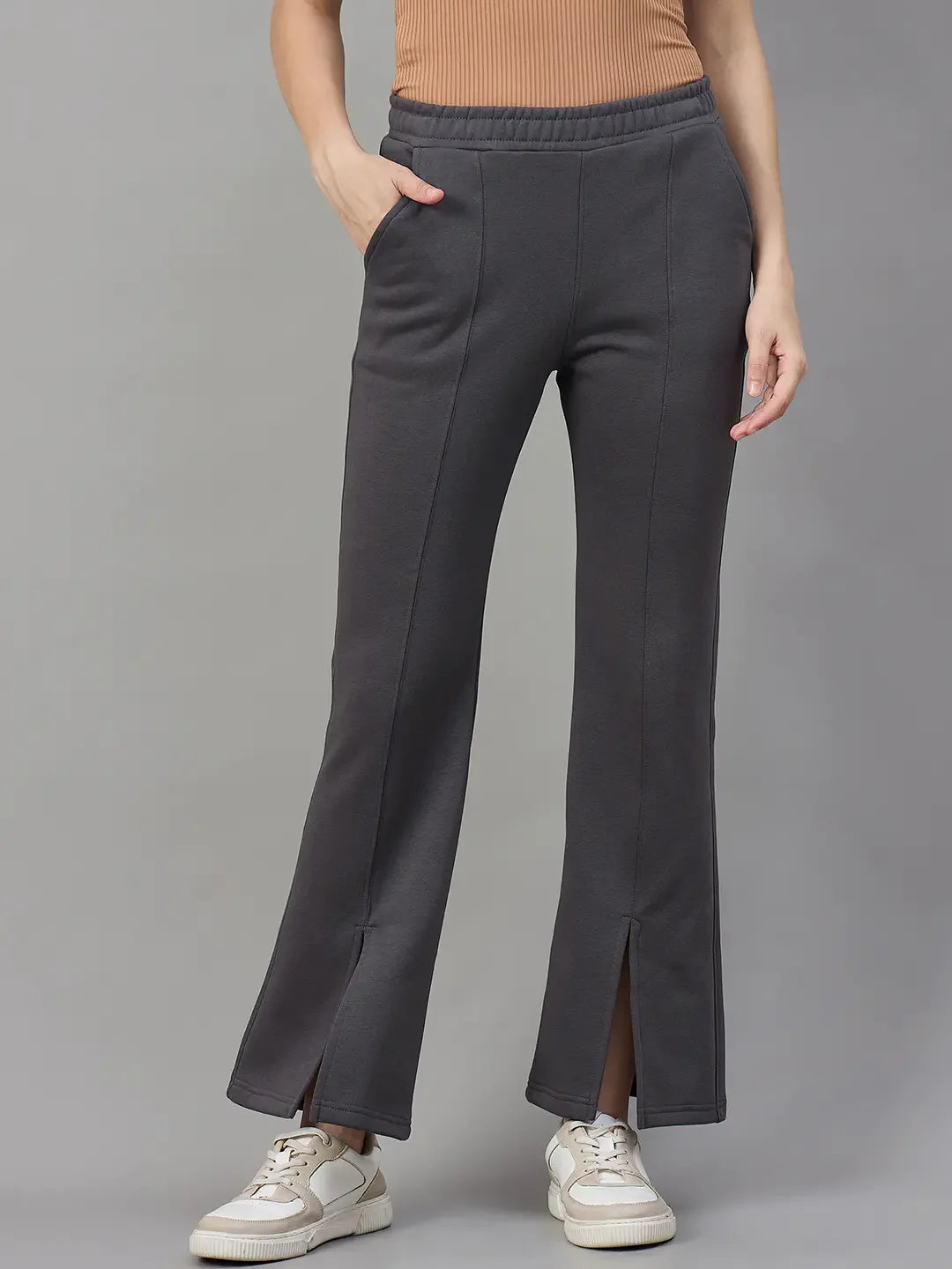 A woman wears 98degreenorth charcoal grey bootcut sweatpants, styled with white sneakers, against a plain background.