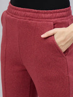 A woman models 98degreenorth Cherry Mélange Flared Side-Slit Sweatpants, one hand in pocket, shown waist down.