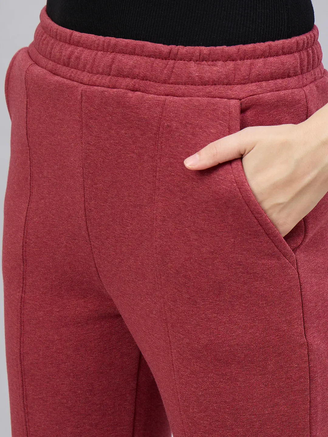 A woman models 98degreenorth Cherry Mélange Flared Side-Slit Sweatpants, one hand in pocket, shown waist down.