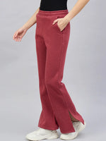 Person in 98degreenorth’s Cherry Mélange Bootcut Sweatpants with side slits, white sneakers, and a black top.