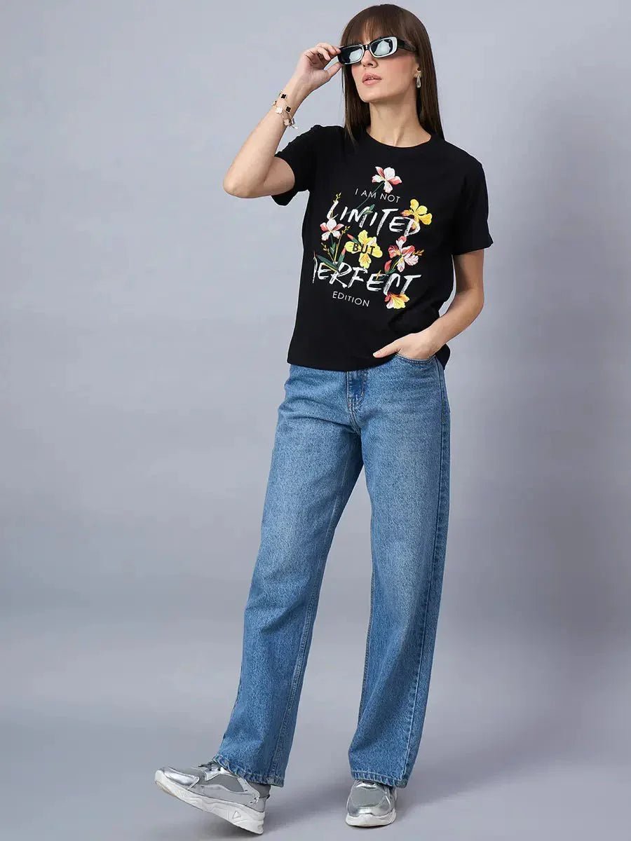 Woman in sunglasses rocks a 98degreenorth Cotton Typography Graphic Tee—casual streetwear style with blue jeans and sneakers.
