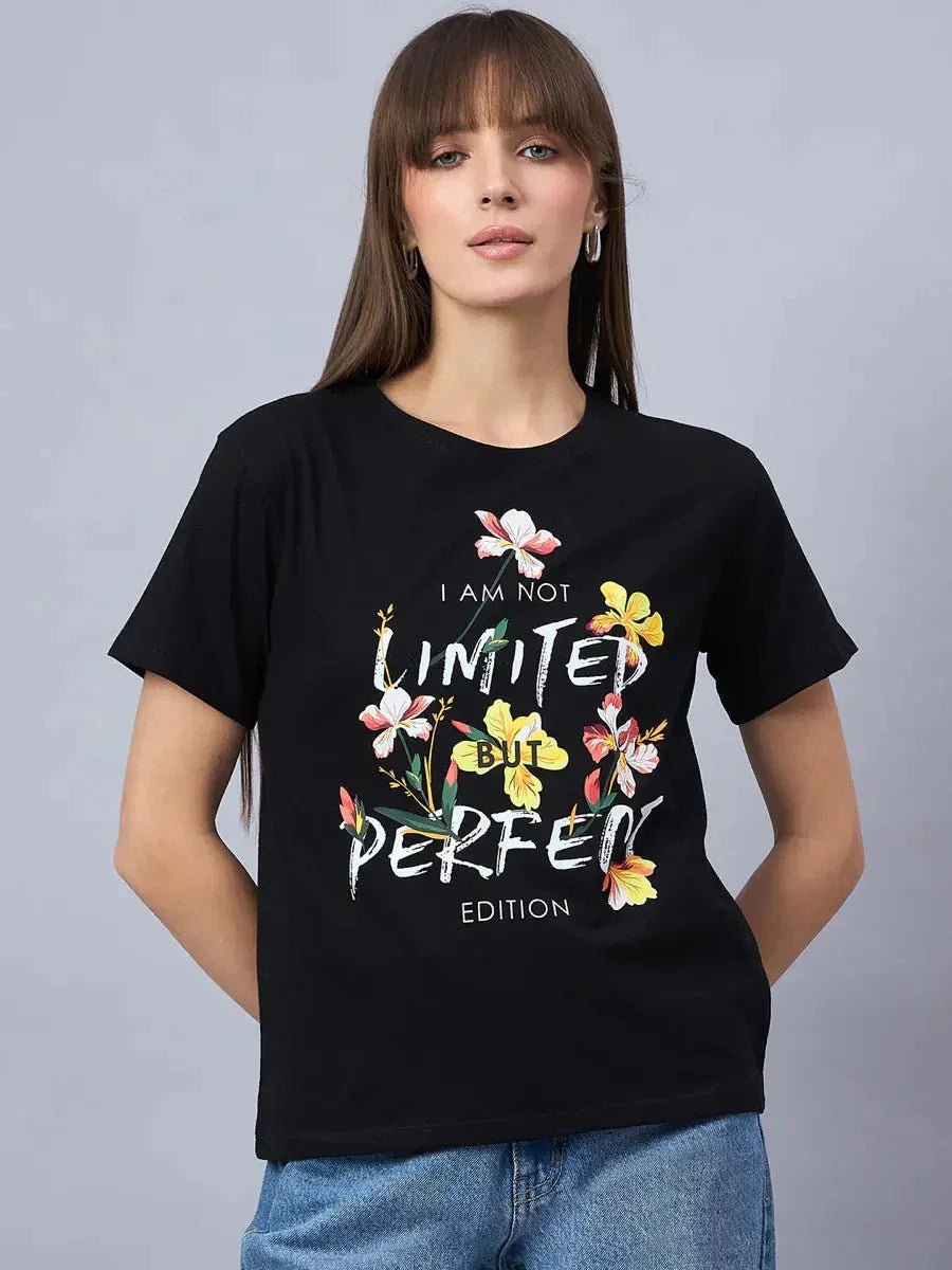 A woman wears a 98degreenorth Women’s Cotton Typography Graphic Tee—Casual Streetwear Style—against a gray background.