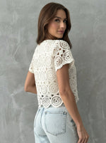 Woman wears 98degreenorth Women's Crochet Lace Crop Top - Off White with short sleeves and scalloped hem.