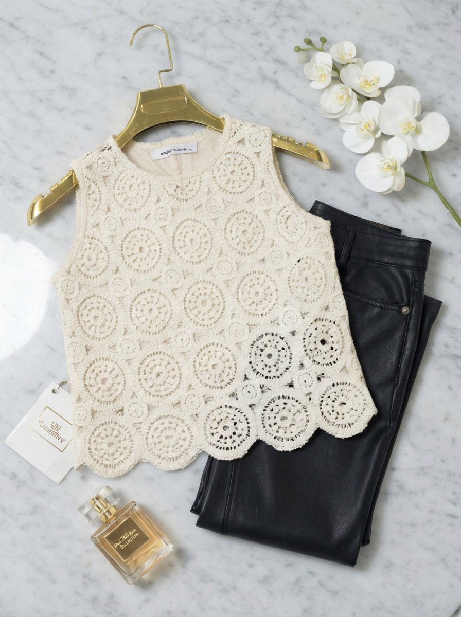 98degreenorth's beige crochet lace sleeveless crop top pairs perfectly with black pants, perfume, and a white orchid.