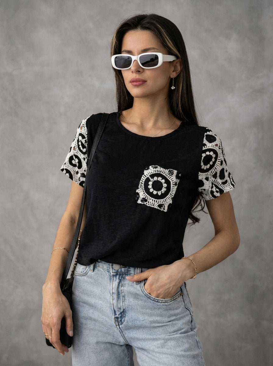 Woman wears 98degreenorth’s Women's Crochet Sleeve Contrast Top in black with lace detail, white sunglasses, and blue jeans.