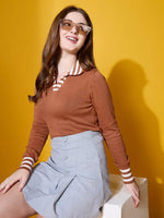 Smiling woman in glasses wears the 98degreenorth Women’s Dark Camel Striped-Collar Knit Sweater against a yellow background.