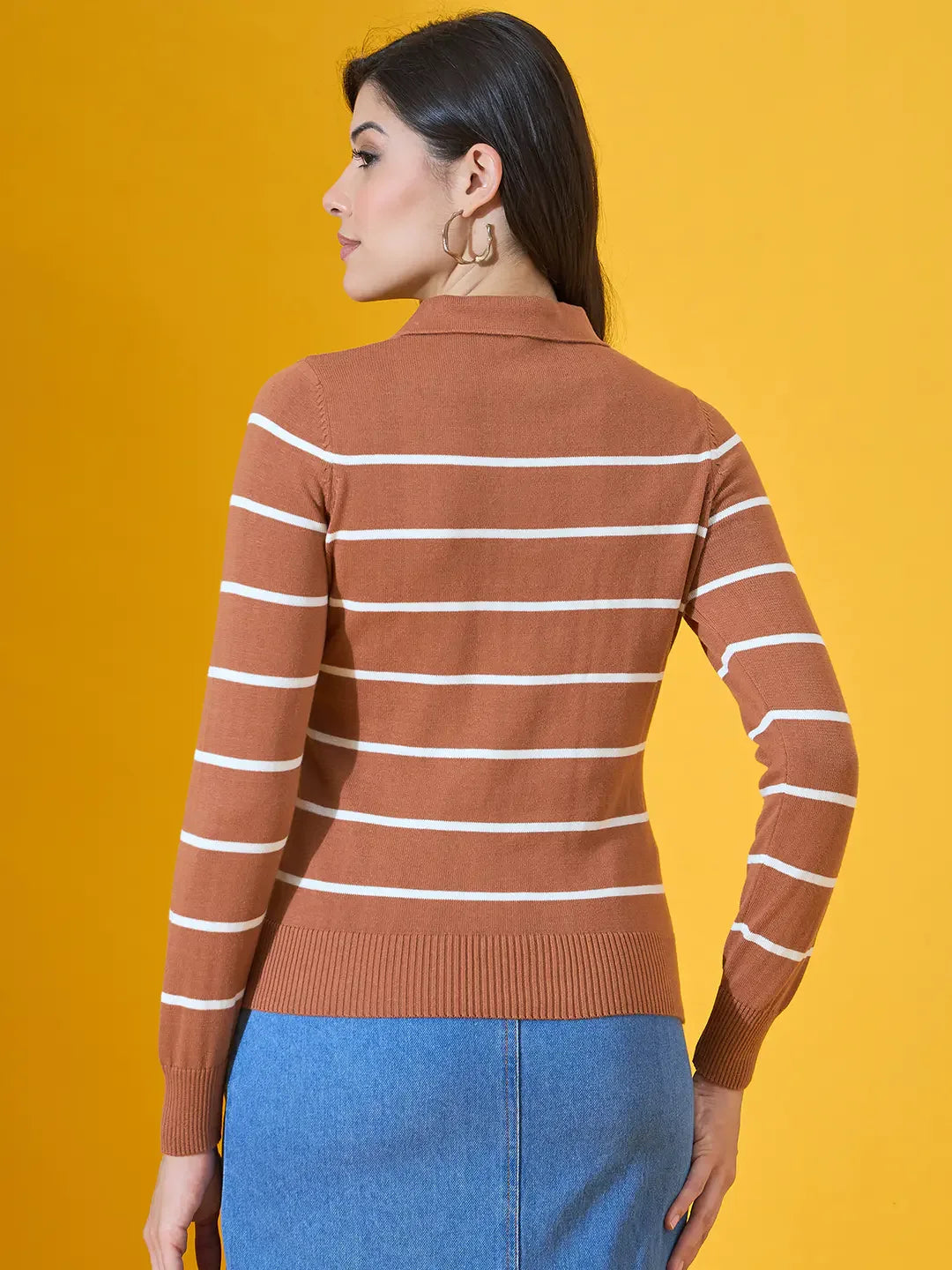 Woman wears 98degreenorth’s Dark Camel Striped Collared Sweater, standing before a vibrant yellow background.