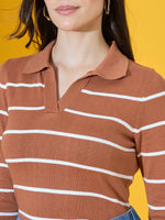 A woman in a 98degreenorth Dark Camel Striped Collared Sweater stands against a bright yellow background.