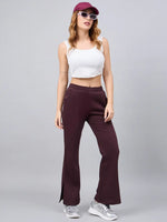 Woman wears 98degreenorth Dark Wine Bootcut Sweatpants—elegant flared lounge pants with side slit—posing stylishly.