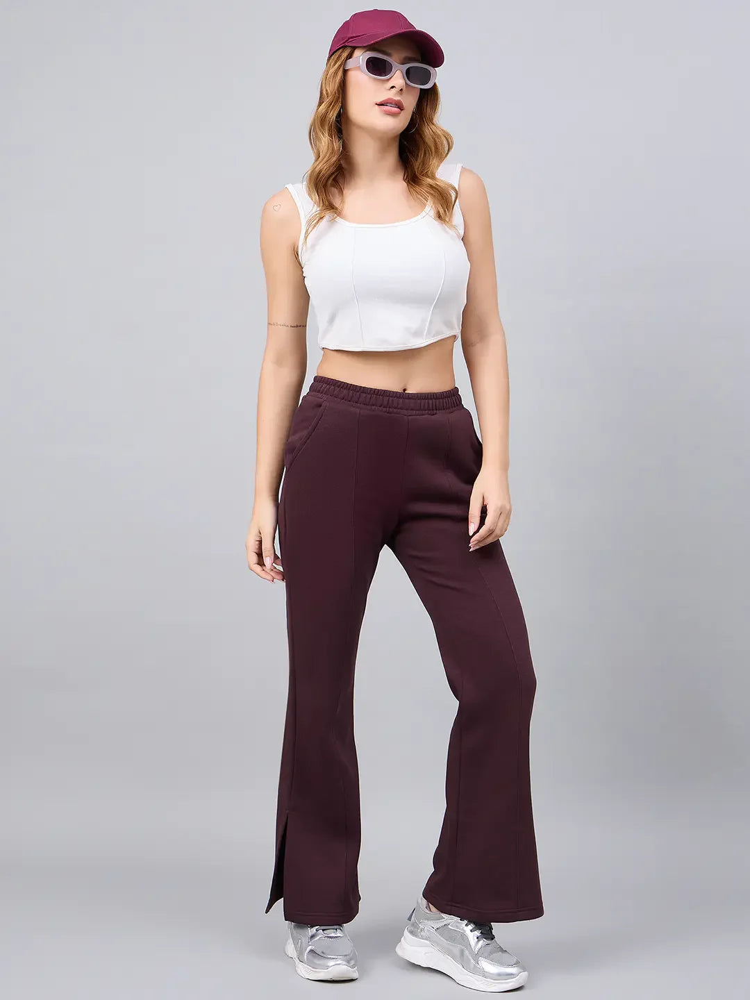 Woman wears 98degreenorth Dark Wine Bootcut Sweatpants—elegant flared lounge pants with side slit—posing stylishly.