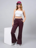 Woman in a white crop top wears 98degreenorth’s Dark Wine Bootcut Sweatpants with side slit for a relaxed, stylish look.