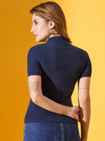Woman wears 98degreenorth denim blue ribbed turtle neck sweater, facing away; butterfly tattoo visible on arm.