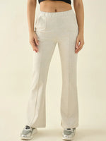 Woman in 98degreenorth Women’s Ecru Flared Bootcut Cotton Stretchable Trousers, black crop top, gray sneakers.