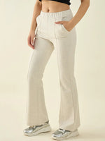 Woman wearing 98degreenorth Women’s Ecru Flared Bootcut Cotton Stretchable Trousers with silver sneakers and a cropped top.