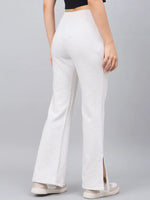 Person in 98degreenorth Women’s Ecru Flared Bootcut Sweatpants with side slits and white sneakers, seen from behind.