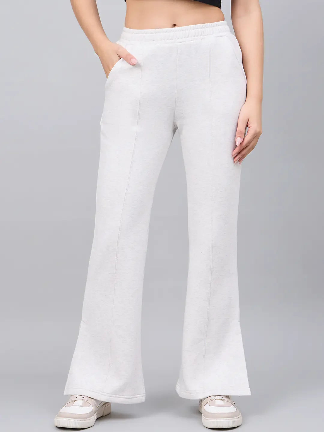 Woman wears 98degreenorth Ecru Flared Bootcut Sweatpants—soft cotton fleece, side-slit—hands in pockets.