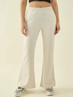 Person in 98degreenorth Ecru Flared Bootcut Trousers, silver sneakers, black crop top, against a plain background.