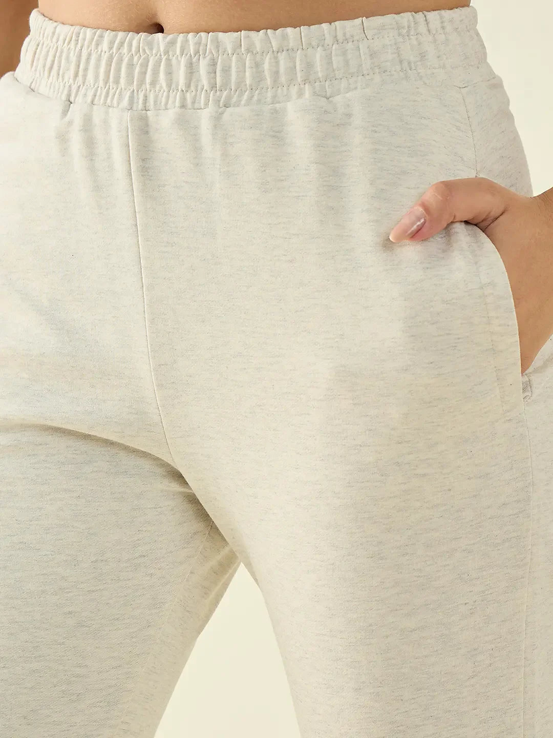 Close-up of a person wearing 98degreenorth Women’s Ecru Flared Fit Bootcut Cotton Stretchable Trousers, hand in pocket.
