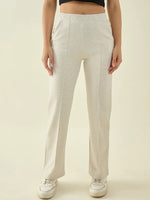 Woman in 98degreenorth Ecru Straight Fit Cotton Stretchable Trousers and white sneakers, against a plain background.