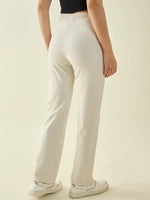Person in 98degreenorth Women’s Ecru Straight Fit Cotton Stretchable Trousers, white sneakers, black top, seen from the back.