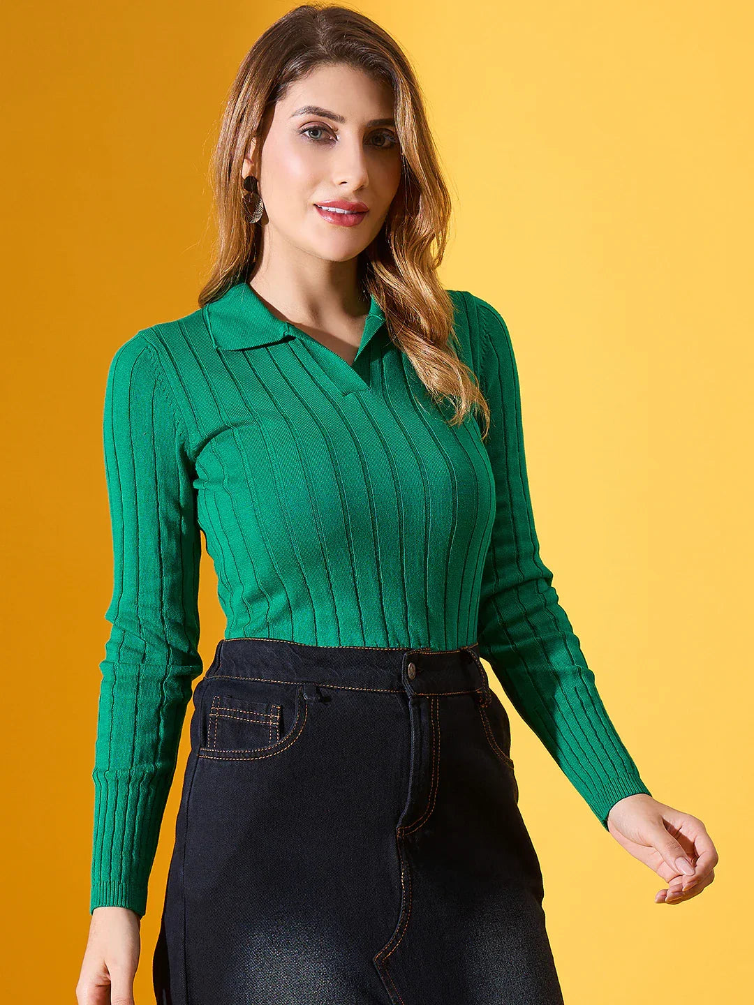 Model wears 98degreenorth Women’s Emerald Green Ribbed Collar Sweater, paired with a black skirt, against yellow background.