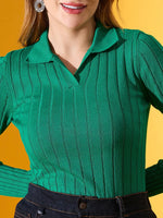 Woman wears 98degreenorth’s emerald green ribbed collar sweater and dark jeans, smiling against a yellow backdrop.