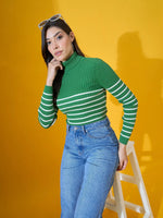 Woman wears 98degreenorth’s Fern Green Ribbed Knit Turtleneck Sweater, styled with jeans on a yellow backdrop.