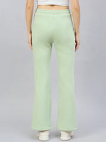 Woman wears 98degreenorth Women’s Flared Bootcut Fleece Sweatpants in Pista, shown from the back on a plain background.