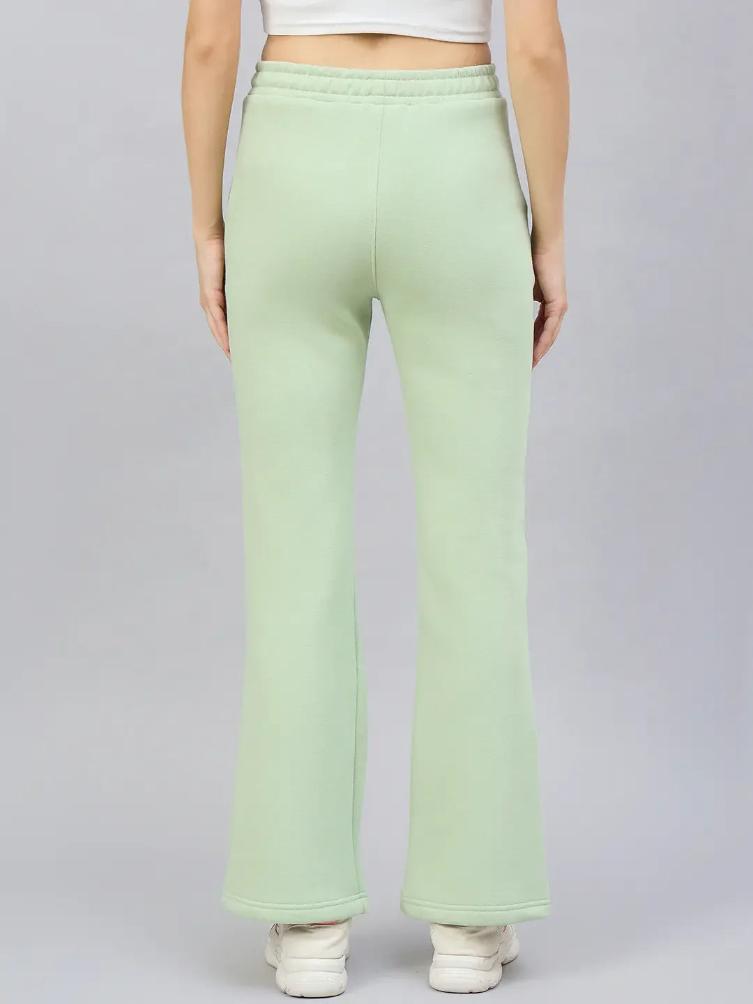 Woman wears 98degreenorth Women’s Flared Bootcut Fleece Sweatpants in Pista, shown from the back on a plain background.