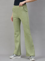Model in 98degreenorth Women’s Flared Bootcut Fleece Sweatpants in Pista Melange with a black top and silver sneakers.