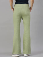 Model wears 98degreenorth Women’s Flared Bootcut Fleece Sweatpants in Pista Melange with a black top and white shoes, back view.