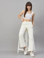 Woman wears 98degreenorth’s Butter Yellow Flared Sweatpants—soft lounge fleece—standing by a stool on gray background.