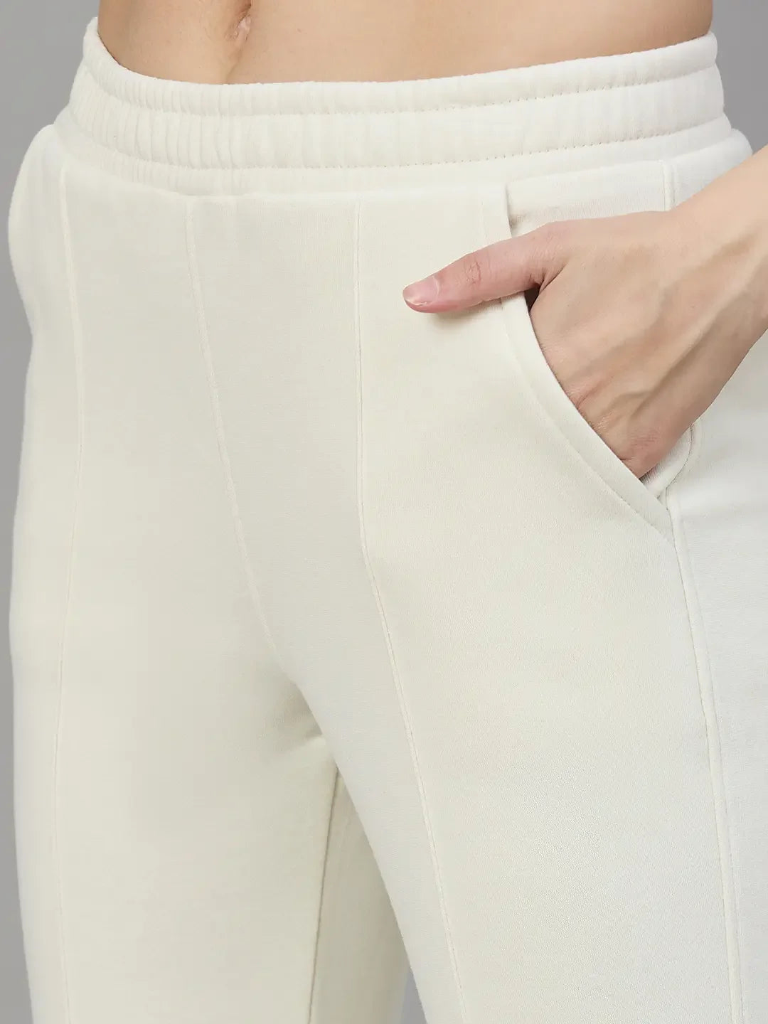 Person wears 98degreenorth Women’s Flared Sweatpants in Butter Yellow—soft lounge fleece pants with pockets and stitch detail.