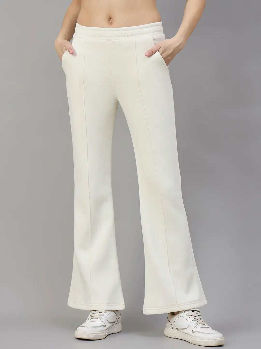 Model wears 98degreenorth Women’s Flared Sweatpants in Butter Yellow with hands in pockets, paired with white sneakers.