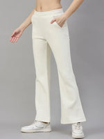 Woman in 98degreenorth Butter Yellow Flared Fleece Sweatpants, smiling against a plain grey background.