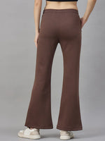 A person wears 98degreenorth Womens Flared Sweatpants in Cocoa Brown, facing away against a gray background.