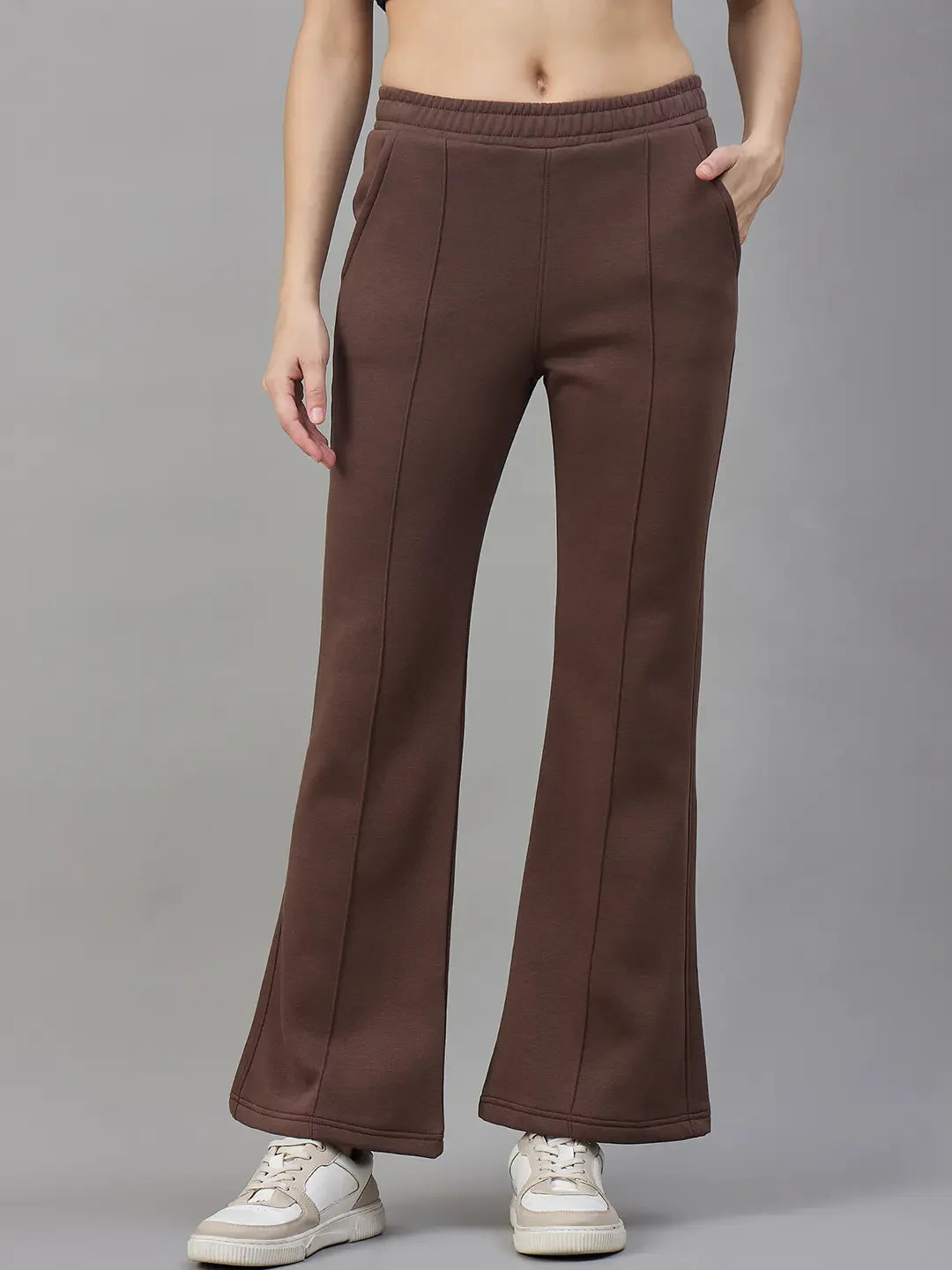 Model wears 98degreenorth Women’s Flared Sweatpants in Cocoa Brown, premium fleece, with white sneakers against a grey backdrop.