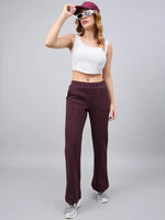 Woman in 98degreenorth Women’s Flared Sweatpants in Dark Wine, white crop top, maroon cap, and sunglasses.