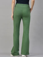 Model in 98degreenorth Women’s Flared Sweatpants in Hunter Green—cozy streetwear for winter, shown with white shoes.