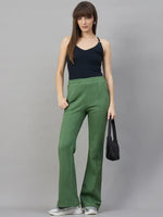 Model wears 98degreenorth Women’s Flared Sweatpants in Hunter Green, styled with a black tank and bag.