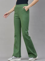 A model wears 98degreenorth Women’s Flared Sweatpants in Hunter Green, posing against a plain gray background.