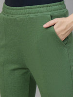 Close-up of a hand in the pocket of 98degreenorth Women’s Flared Sweatpants in Hunter Green—cozy winter streetwear.