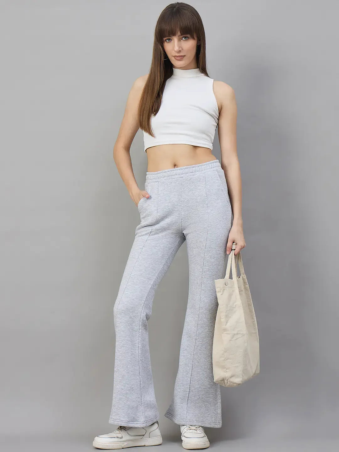 Woman in 98degreenorth’s Light Grey Classic Soft Fleece Flared Sweatpants—perfect winter loungewear.
